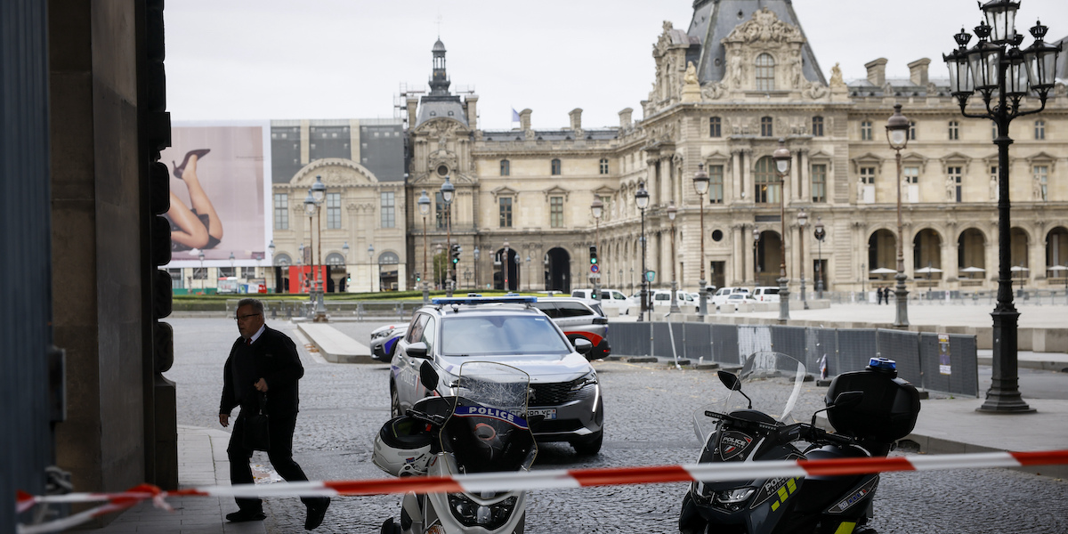 Veicoli della polizia davanti a uno degli ingressi del Louvre, a Parigi, dopo l'evacuazione del museo, il 14 ottobre 2023 (AP Photo/Thomas Padilla)