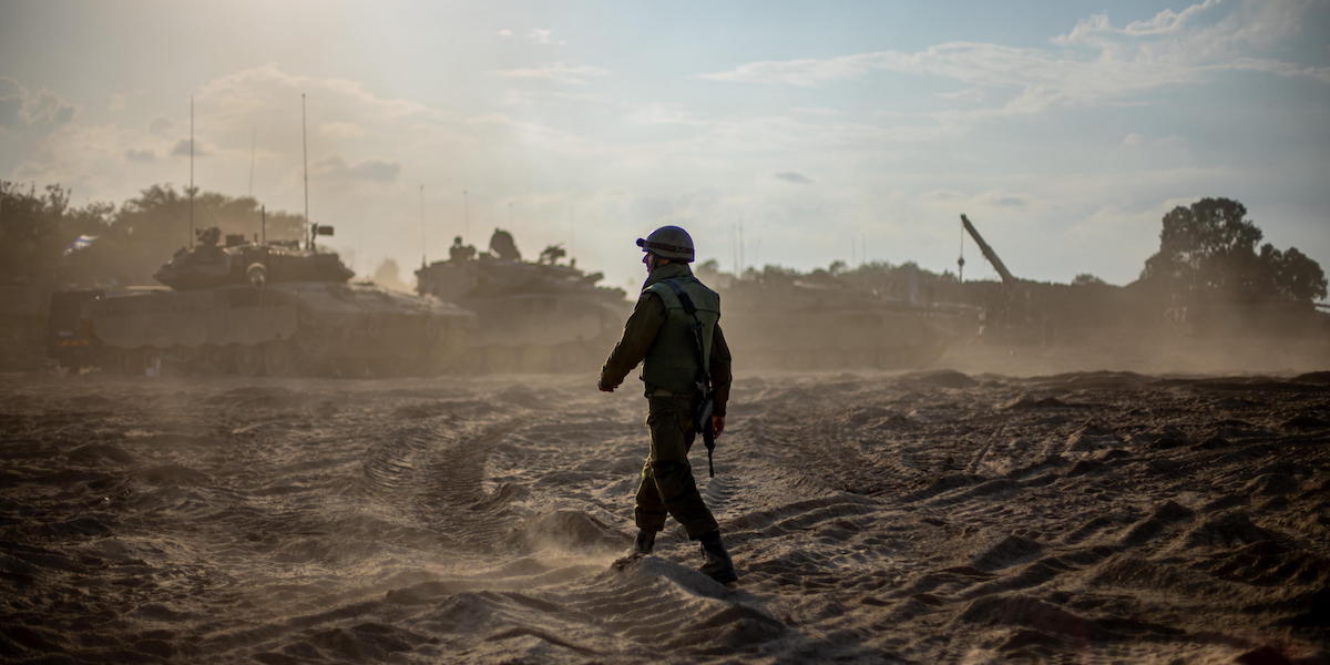 Un soldato israeliano e diversi carri armati israeliani, vicino al confine con la Striscia di Gaza (EPA/MARTIN DIVISEK)