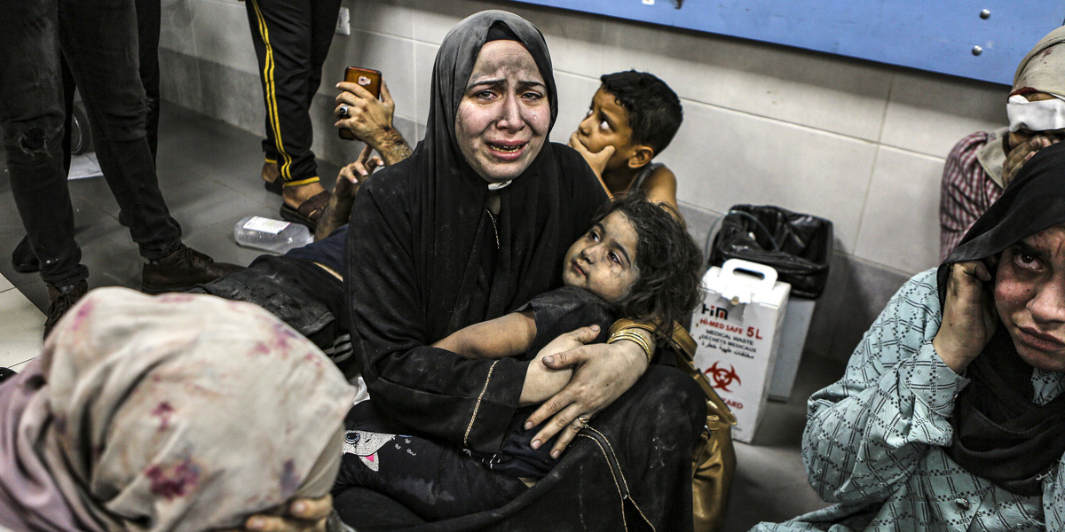 Palestinesi feriti nel bombardamento dell'ospedale al Ahli siedono sul pavimento dell'ospedale al Shifa, nella città di Gaza (AP Photo/Abed Khaled)