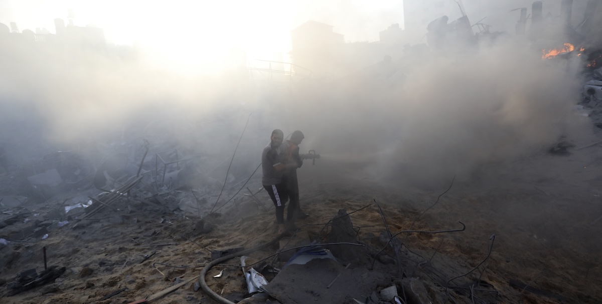 Vigili del fuoco palestinesi spengono un incendio dopo un bombardamento israeliano sulla città di Gaza (AP Photo/Abed Khaled)
