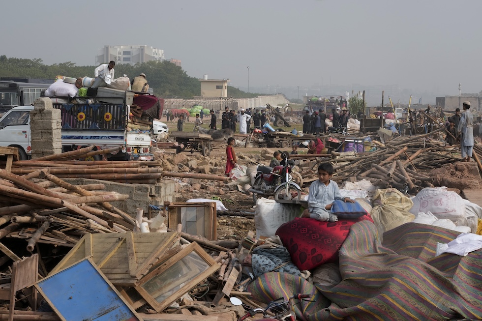 Persone afghane cercano di recuperare le loro cose dalle case in cui vivevano vicino a Islamabad, fatte demolire dal governo pakistano