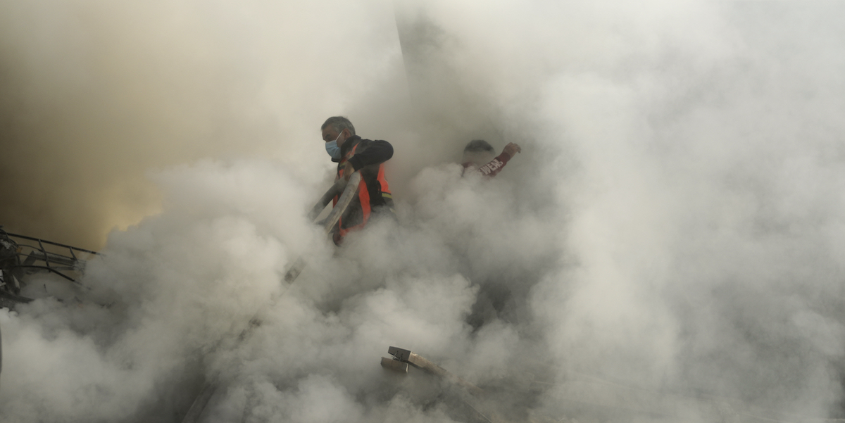 Palestinesi tra le macerie dopo un bombardamento sul campo profughi di Khan Yunis, nel sud della Striscia di Gaza (AP Photo/Mohammed Dahman)