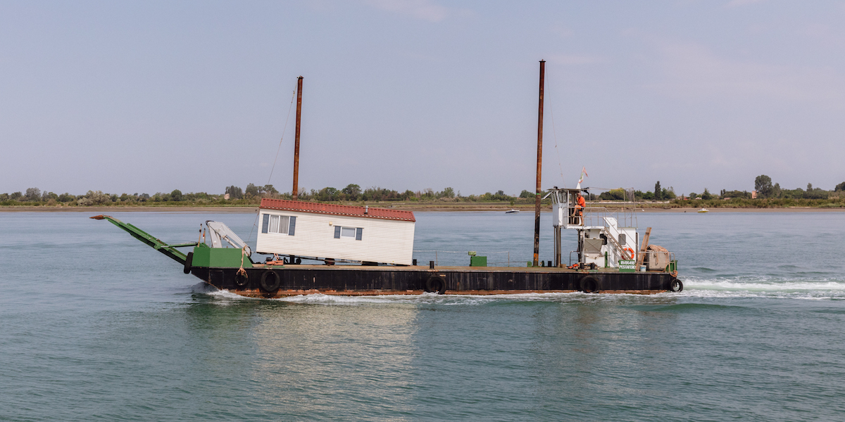 Una casa portatile trasportata su una barca vicino alla bocca di porto del Lido di Venezia (Matteo de Mayda, The Passenger)