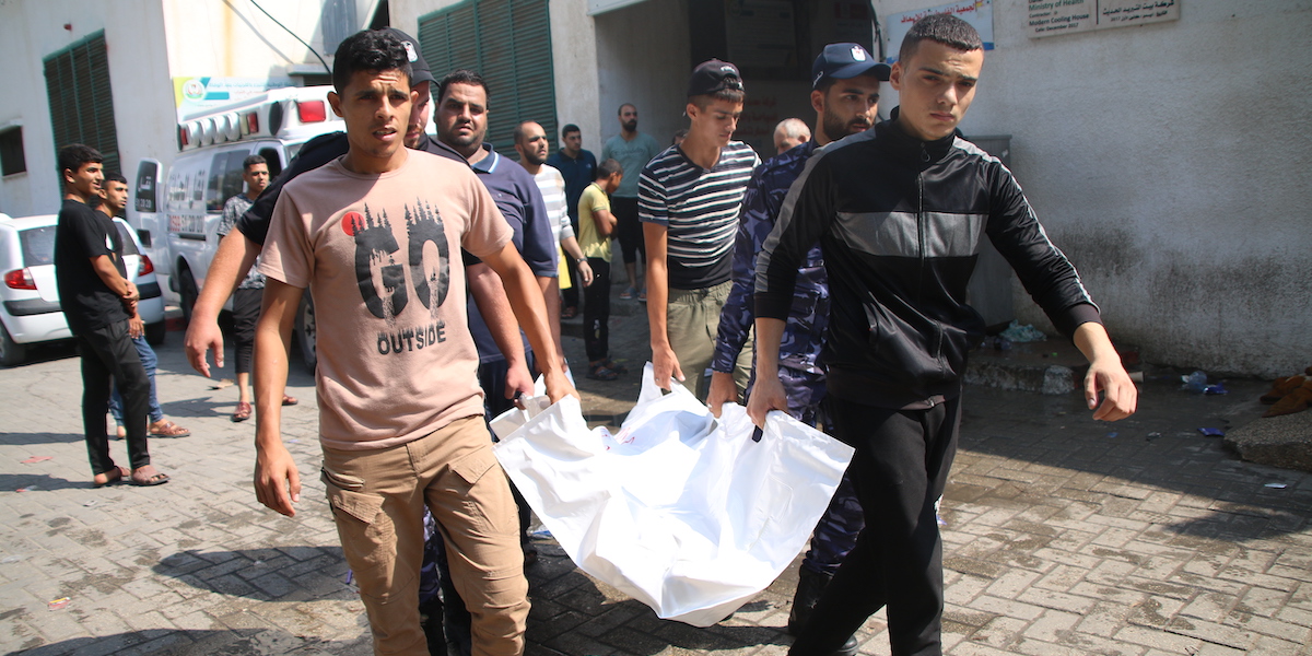 Palestinesi portano un corpo fuori dall'ospedale al Shifa di Gaza (Ahmad Hasaballah/Getty Images)