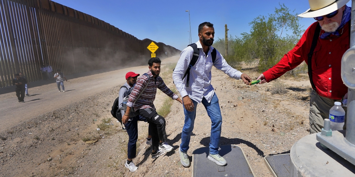 Un volontario assiste delle persone che sono appena entrate negli Stati Uniti dal confine col Messico (AP Photo/Matt York, File)