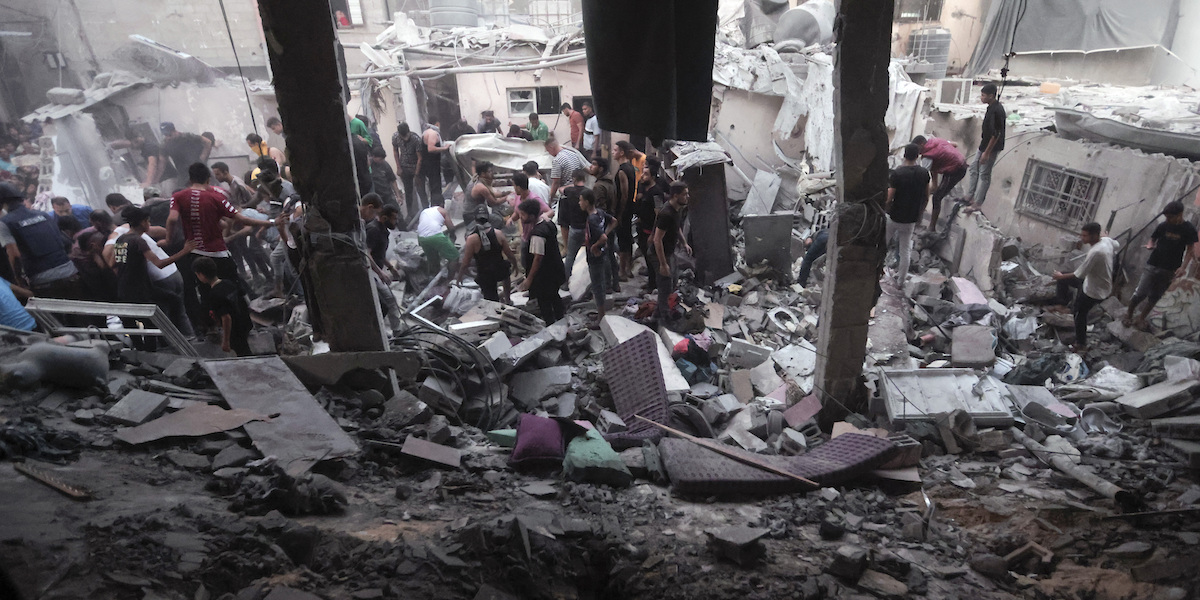 Palestinesi cercano i sopravvissuti tra le macerie dopo un bombardamento sul campo profughi di Khan Yunis, nel sud della Striscia di Gaza (AP Photo/Mohammed Dahman)