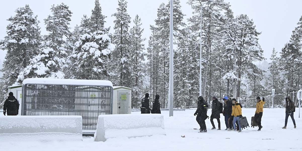 Richiedenti asilo arrivano al passaggio di frontiera di Raja-Jooseppi, tra Russia e Finlandia, il 25 novembre del 2023 (Emmi Korhonen/Lehtikuva via AP)