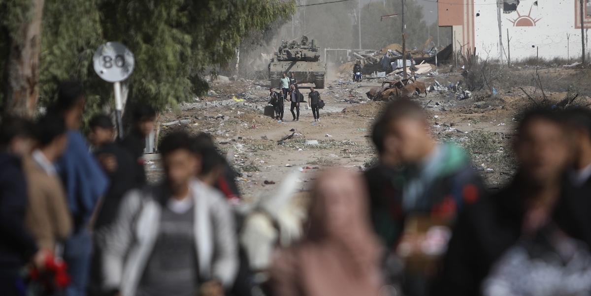 Civili palestinesi lasciano il nord della Striscia di Gaza mentre un carro armato israeliano blocca la strada Salah al-Din, la più importante della Striscia. (AP Photo/Mohammed Dahman)