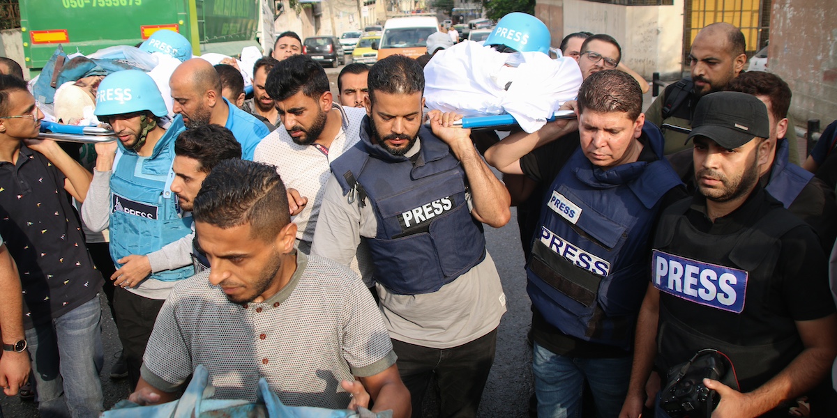 Amici e colleghi portano i corpi dei giornalisti palestinesi Muhammad Sobh e Saeed Al-Taweel, uccisi dai bombardamenti israeliani sulla città di Gaza il 10 ottobre (Ahmad Hasaballah/Getty Images)