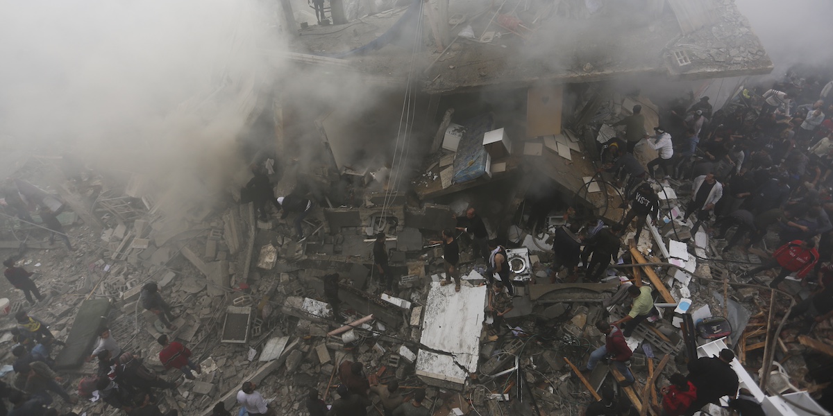 Giovedì alcuni palestinesi soccorrono le persone morte e ferite in un attacco israeliano a Rafah (AP Photo/Hatem Ali)