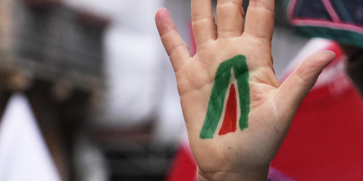 nella foto c'è un logo di Alitalia disegnato sulla mano di un lavoratore