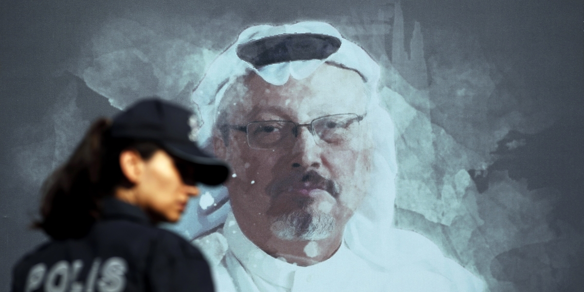 Un'agente di polizia davanti a un'immagine di Jamal Khashoggi