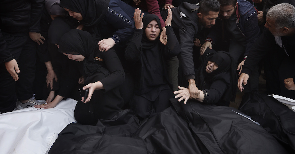 Alcune persone palestinesi con i cadaveri dei morti in un bombardamento israeliano a Khan Younis (AP Photo/Mohammed Dahman)