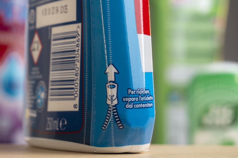 Il messaggio "Per riciclare separa l'etichetta dal contenitore" su un flacone di brillantante