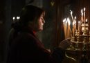 Una mujer enciende una vela en la Iglesia de Panagia Kapnicaria, una de las iglesias ortodoxas griegas más antiguas del país.