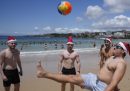 Niños con gorros de Papá Noel juegan al fútbol en Bondi Beach
