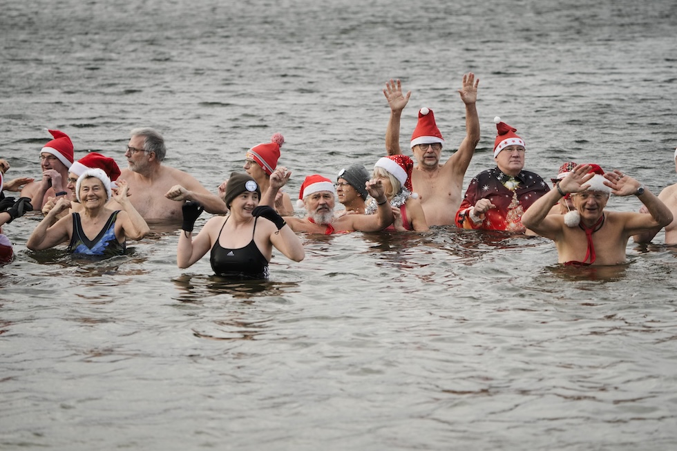 Persone durante il tradizionale bagno di Natale nel lago Orankesee
