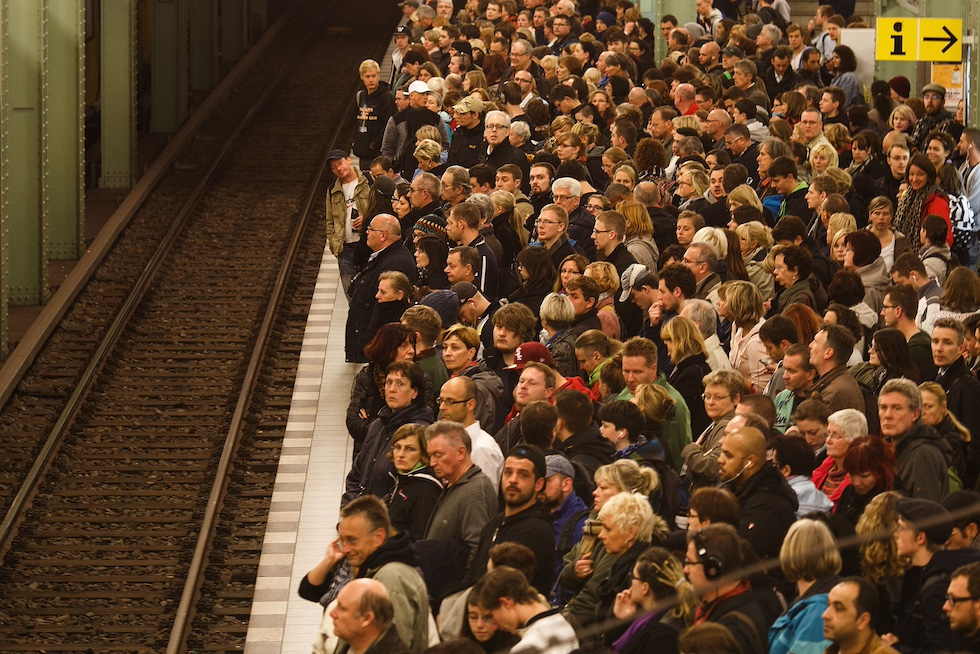 Una folla di persone in attesa nella stazione della metropolitana Alexanderplatz a Berlino