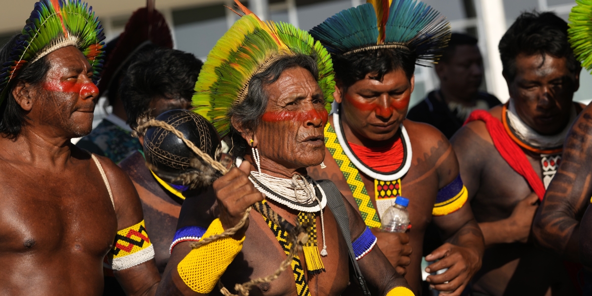 tre persone vestite in abiti tradizionali eseguono una danza rituale