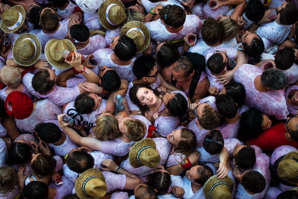 Una ragazza vista dall'alto solleva la testa all'insù mentre è a stretto contatto con altre persone in una folla molto densa