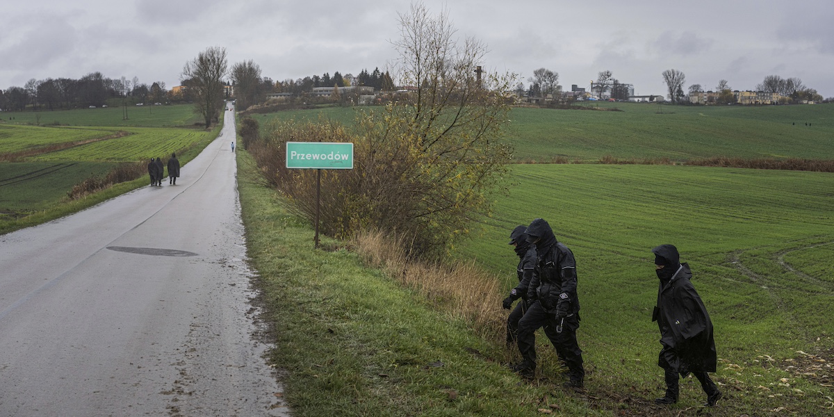 Agenti della polizia polacca cercano i resti di un missile caduto vicino al confine con l'Ucraina, nel 2022 (AP Photo/Evgeniy Maloletka)