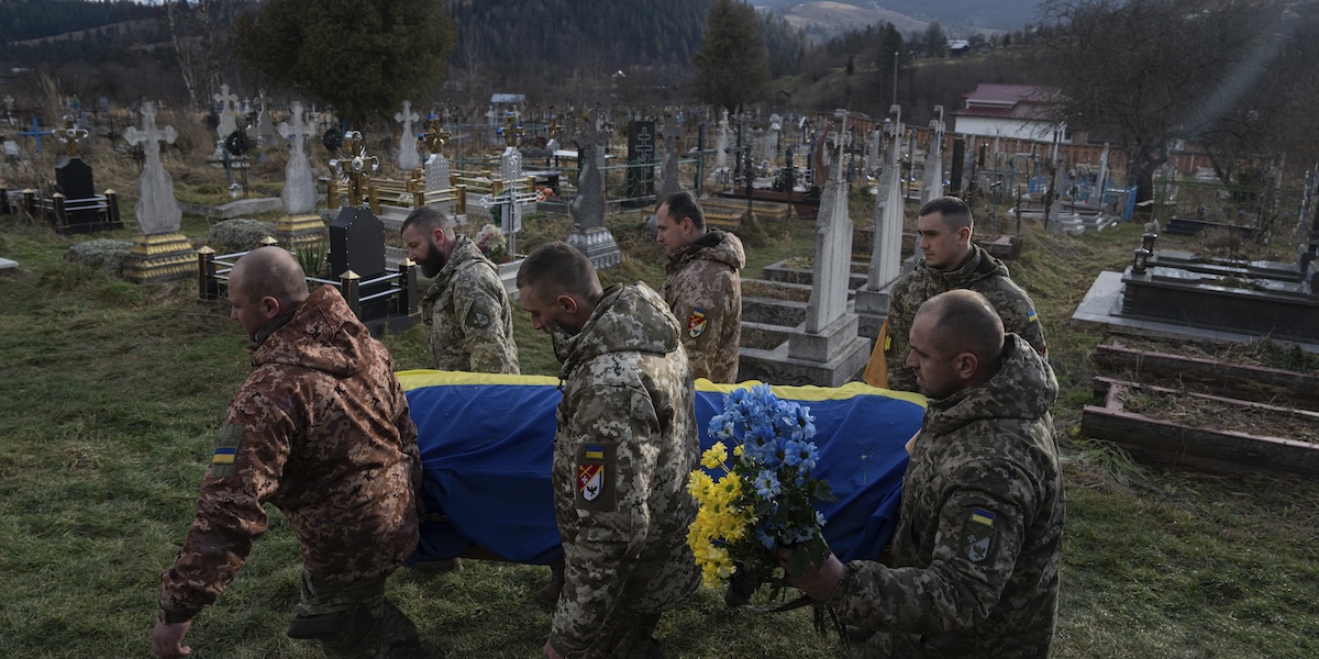 Combattenti ucraini trasportano in un cimitero di Iltsi la bara del soldato Vasyl Boichuk, il 26 dicembre 2023 (AP Photo/Evgeniy Maloletka)