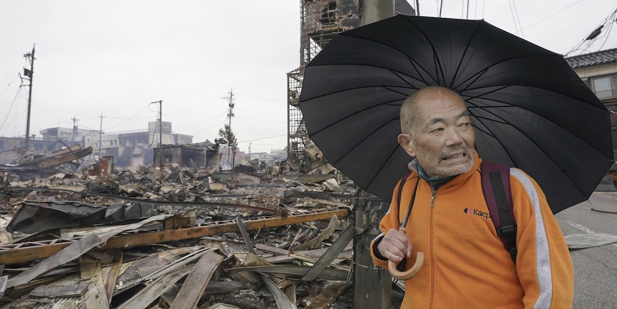 Un uomo tra i palazzi distrutti nella città di Wajima (Kyodo News via AP)