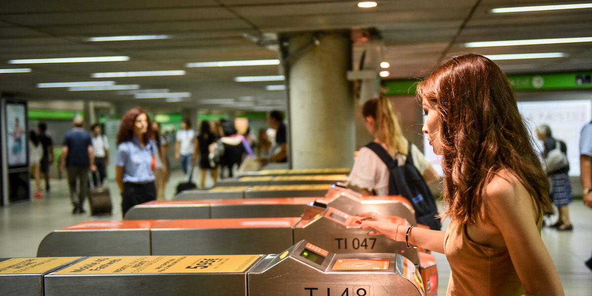 Foto di una ragazza che passa i tornelli della metro a Milano