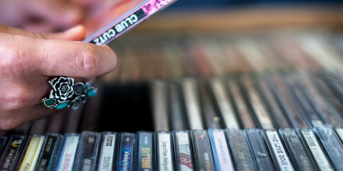 una donna afferra un cd da uno scaffale in un negozio di dischi