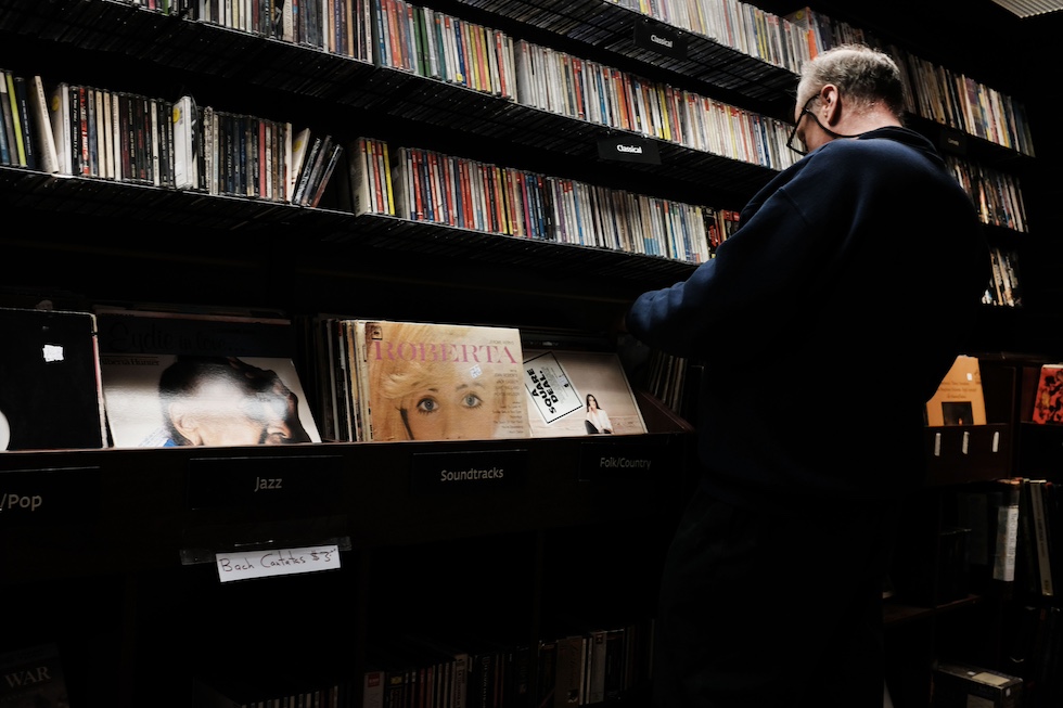 Un uomo rovista tra i dischi in un negozio a New York