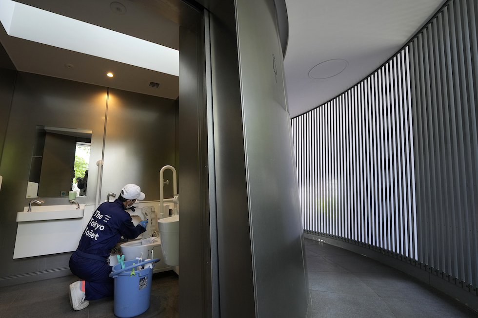 Un addetto alle pulizie del Tokyo Toilet Project pulisce uno dei bagni pubblici