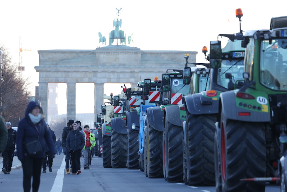 Trattori allineati davanti alla Porta di Brandeburgo nel primo giorno di proteste degli agricoltori contro le misure proposte dal governo che ridurrebbero i benefici federali per il settore agricolo (Sean Gallup / Getty Images)