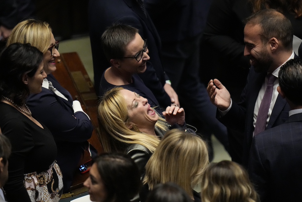La presidente del Consiglio Giorgia Meloni ride con colleghi e colleghe di partito durante una votazione in parlamento