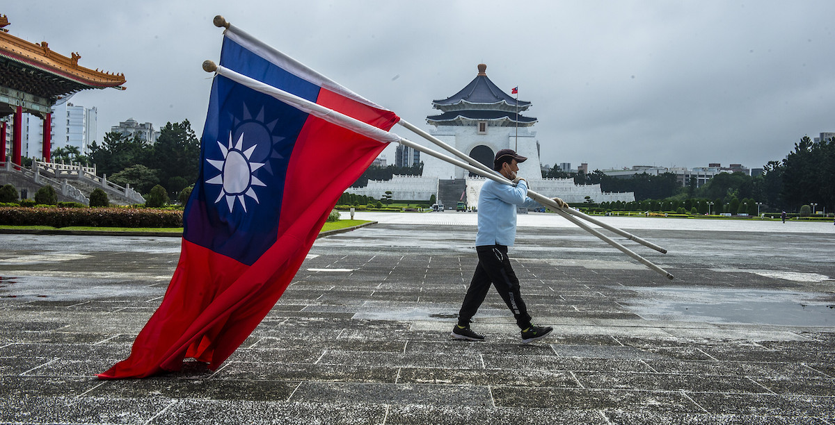 Un uomo trasporta bandiere taiwanesi a Taipei