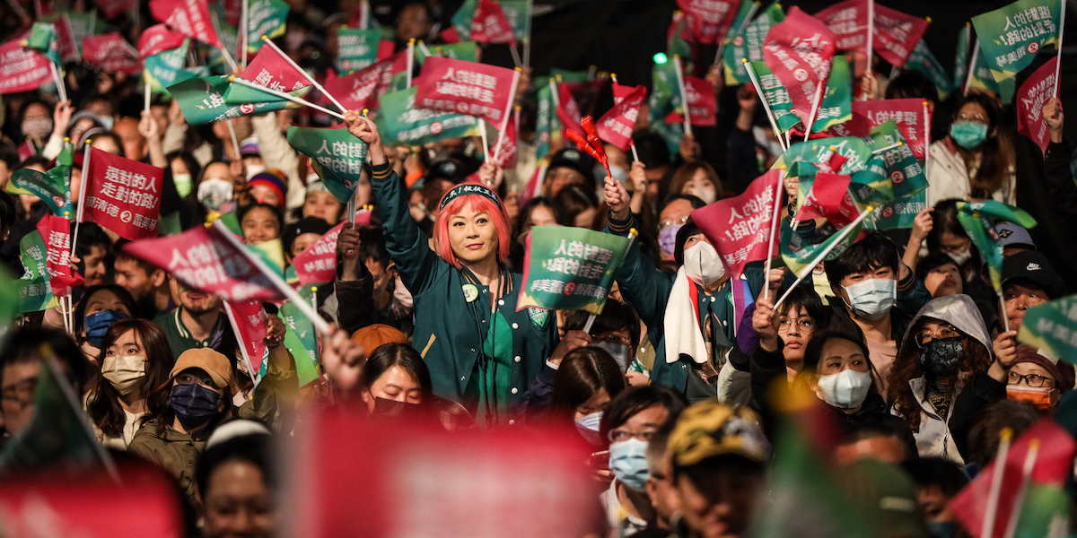 Foto di una ragazza con la parrucca rosa in mezzo a una folla di sostenitori del partito di Lai in festa