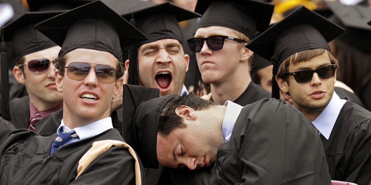 Uno studente fa un pisolino e un altro sbadiglia in un gruppo di laureandi durante una cerimonia di laurea al Boston College