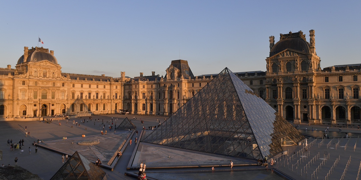 Una vista del cortile del Louvre al tramonto con la piramide di vetro al centro