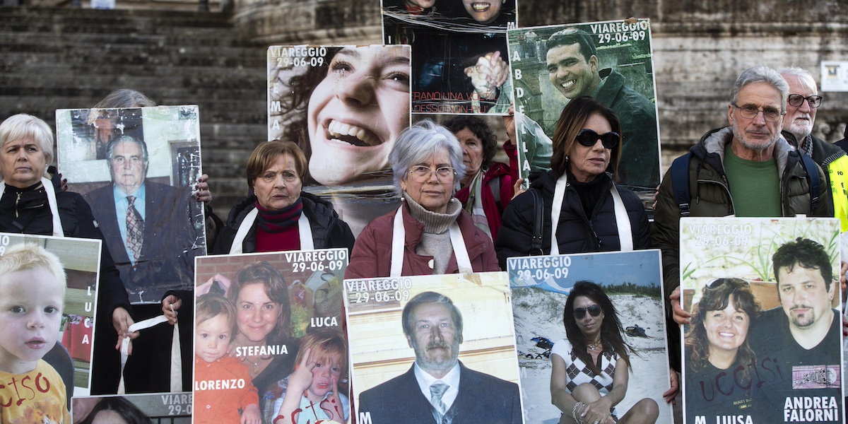 Famigliari delle vittime mostrano le loro foto davanti alla Corte Suprema di Cassazione in attesa dell'ultima sentenza sulla strage ferroviaria di Viareggio a Roma, il 15 gennaio 2024 (ANSA/ANGELO CARCONI)