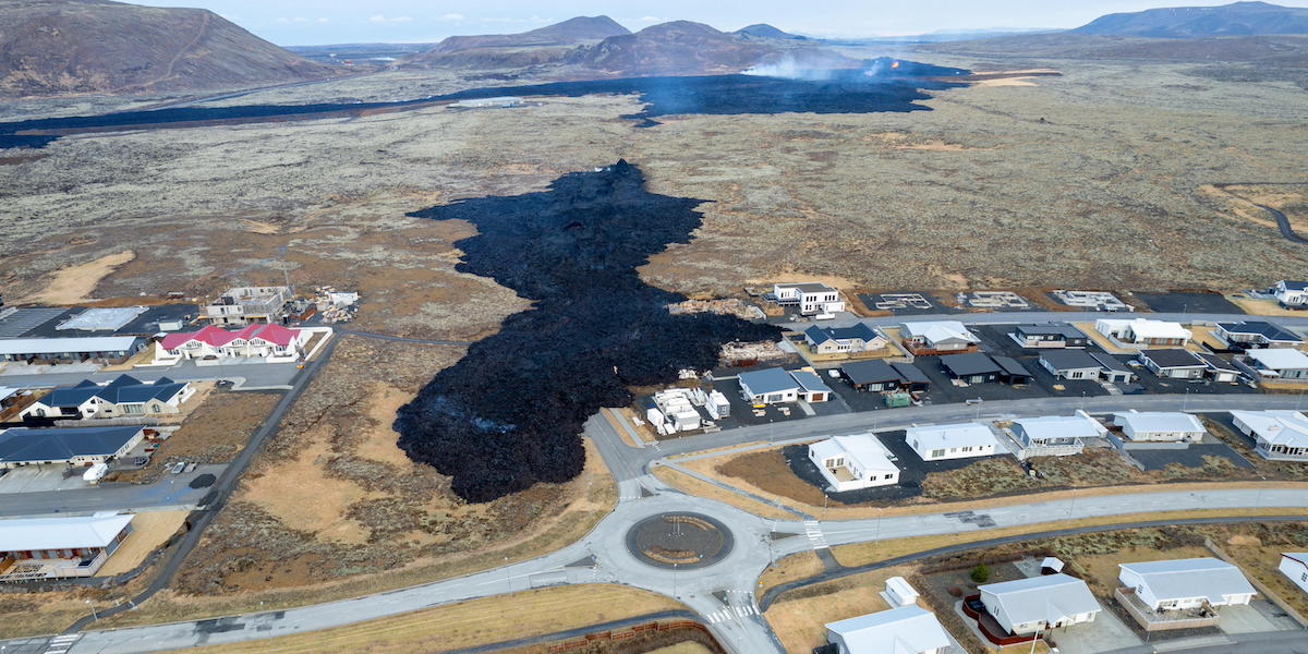 La lava che ha coperto parzialmente una strada di Grindavík e alcune case, vista dall'alto: si sta raffreddando ed è nera