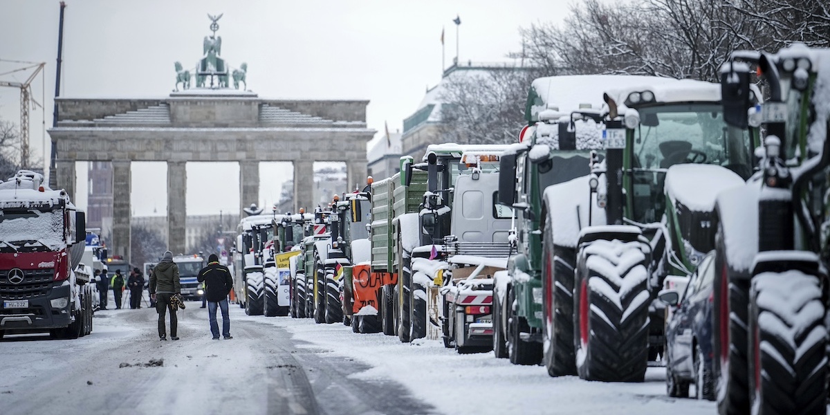 Trattori bloccano la strada davanti alla Porta di Brandeburgo a Berlino durante la manifestazione degli agricoltori del 15 gennaio 2024 (Kay Nietfeld/dpa via AP)