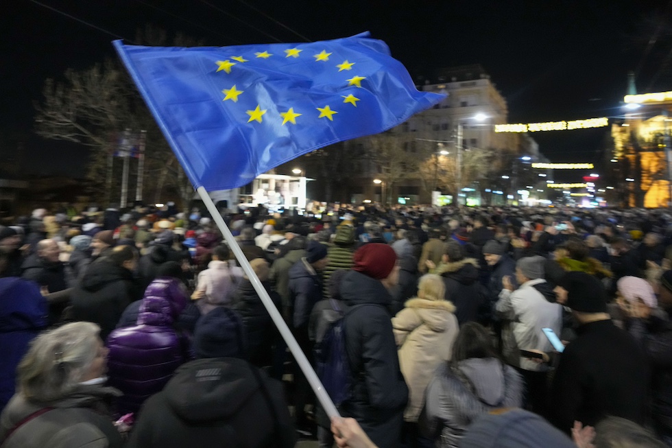 Un manifestante sventola una bandiera dell'UE durante una manifestazione contro il presidente Aleksandar Vucic, il cui partito è accusato di aver falsificato i risultati delle elezioni parlamentari e locali del 17 dicembre (AP/Darko Vojinovic)