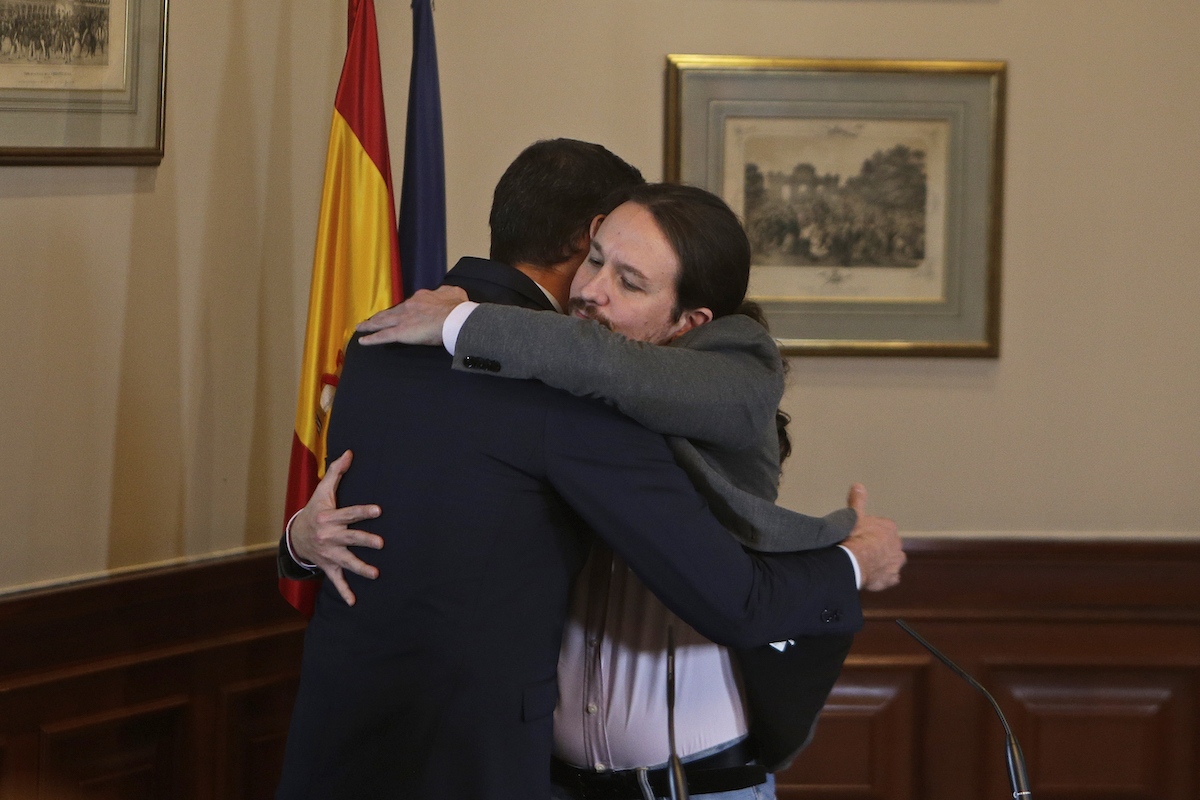 Il celebre e imbarazzato abbraccio tra Sánchez e Iglesias dopo la chiusura dell'accordo per la formazione di un governo di coalizione
