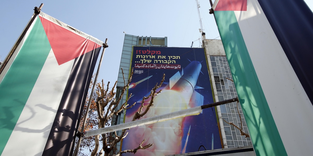Bandiere palestinesi in una piazza di Teheran, in Iran, davanti a un cartellone raffigurante missili iraniani con un messaggio in persiano ed ebraico: «Preparate le vostre bare».