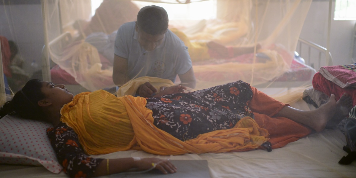 Un uomo assiste la moglie ricoverata per dengue a Dacca, Bangladesh, il 10 agosto 2023 (AP Photo/ Mahmud Hossain Opu)