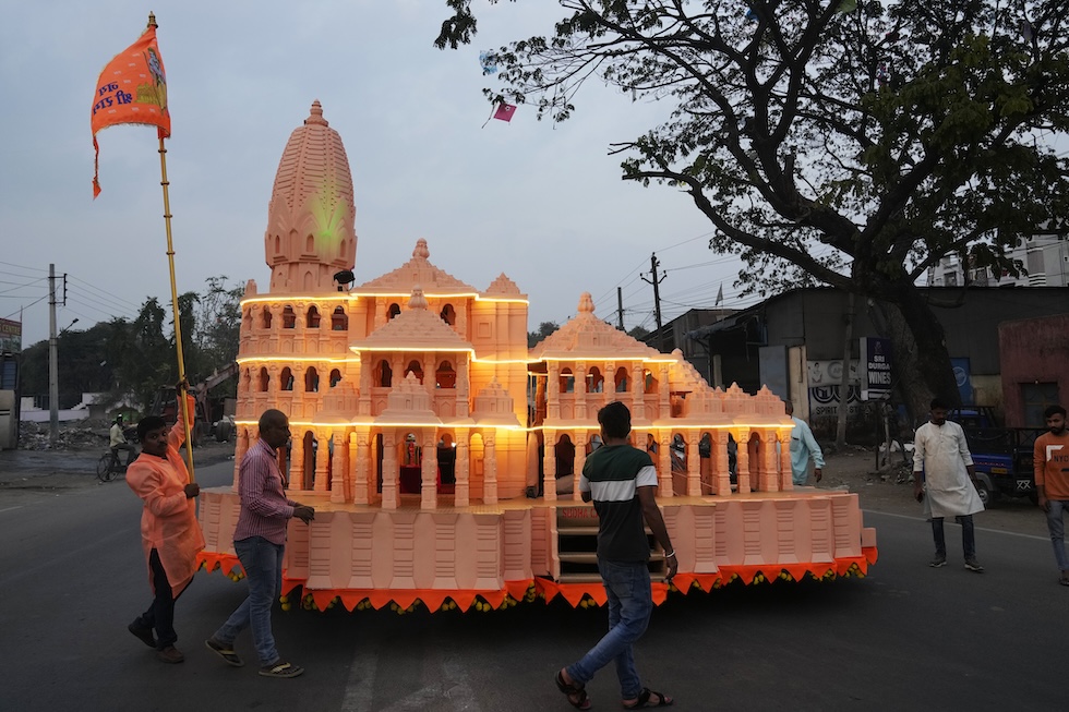Fedeli con un modellino montato su un'auto del tempio di Rama