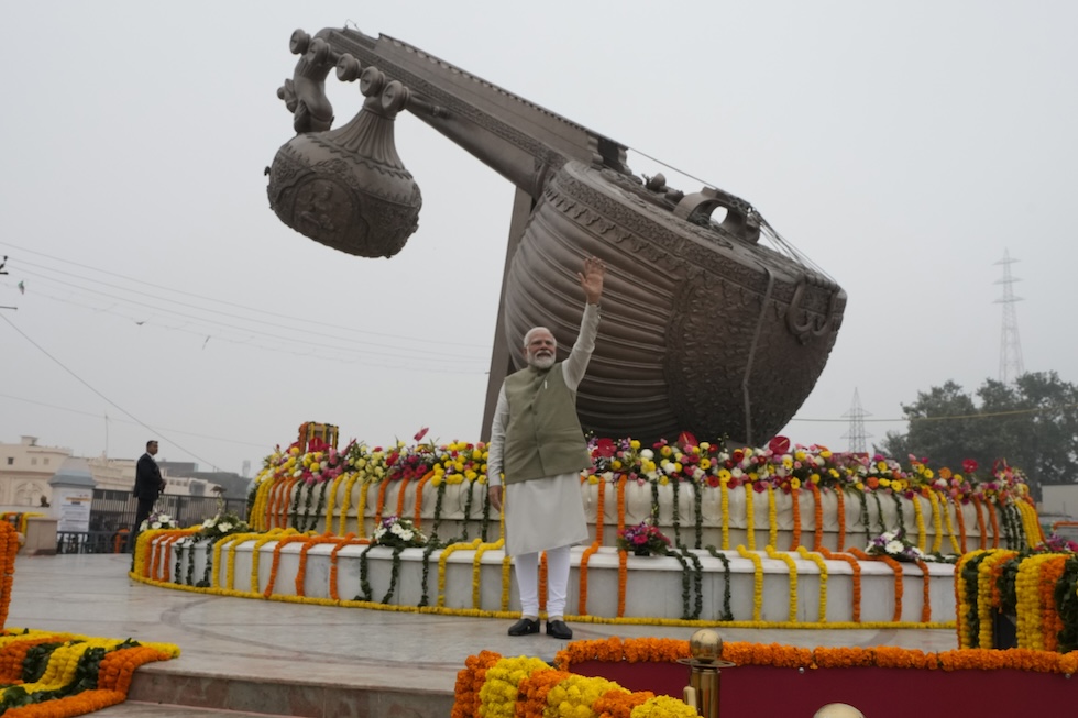 Il primo ministro Modi davanti a un monumento che rappresenta uno strumento musicale