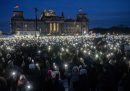 Centinaia di persone con le torce dei cellulari accesi durante la manifestazione contro il partito di estrema destra Alternative für Deutschland davanti alla sede del parlamento tedesco, domenica sera