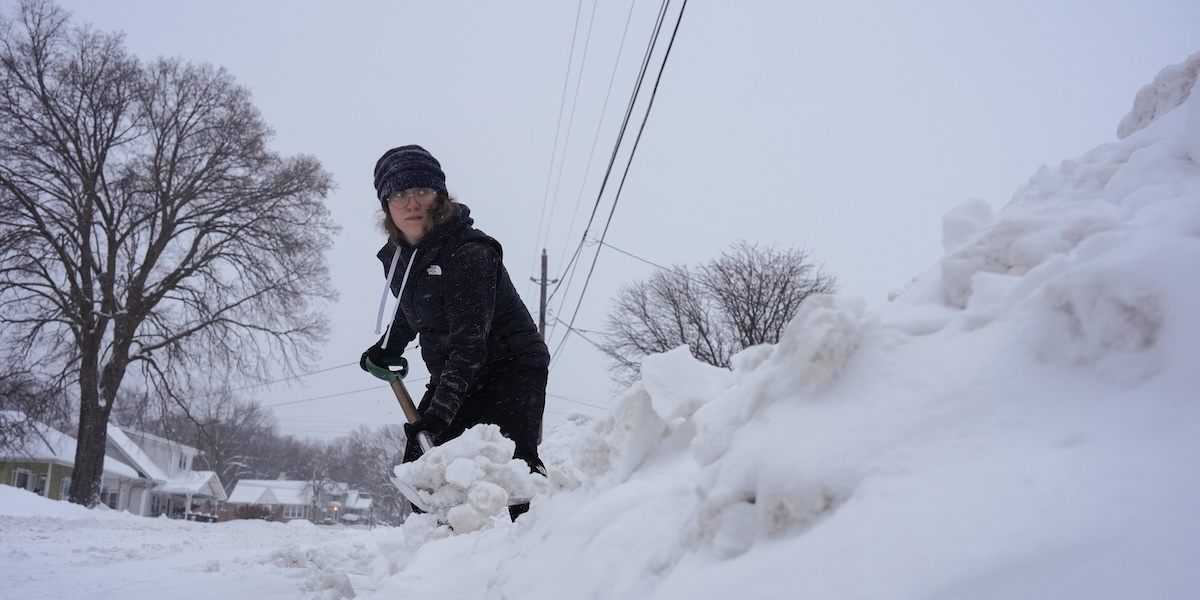 Una donna spala la neve a Sioux City, in Iowa, venerdì 12 gennaio