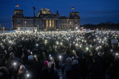 Centinaia di persone con le torce dei cellulari accesi durante la manifestazione contro il partito di estrema destra Alternative für Deutschland davanti alla sede del parlamento tedesco, domenica sera