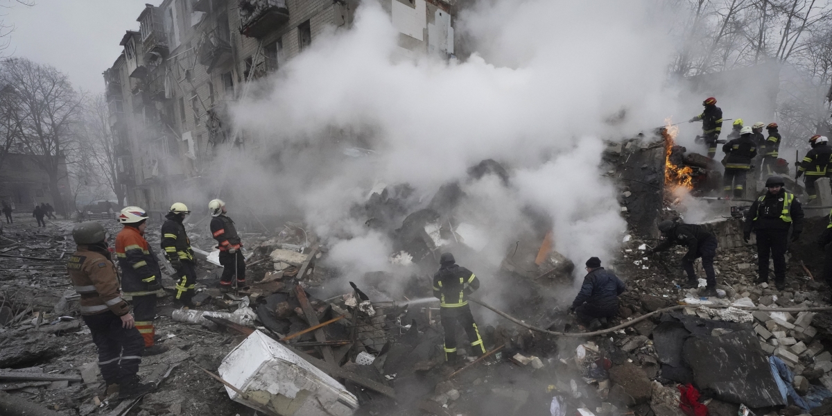 pompieri lavorano in mezzo al fumo che sale dalle rovine di un palazzo distrutto